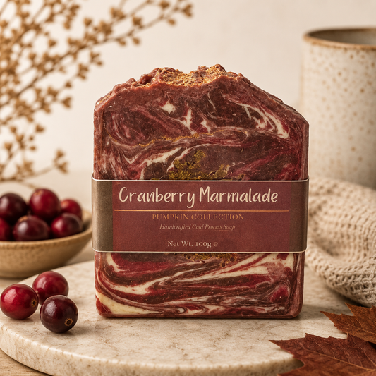 Cranberry Marmalade soap bar with a label, surrounded by cranberries and a woven basket on a neutral background.