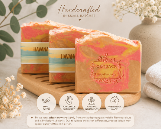 Handcrafted soap bars with 'Outback Body Products' branding on a wooden stand with decorative elements.